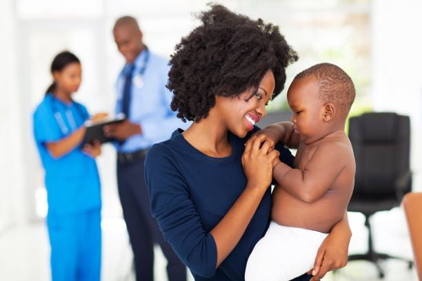 parent, baby, doctor, and nurse at the pediatricians office